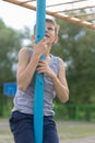 A teenager in a T-shirt climbs on a gymnastic pole Royalty Free Stock Photo
