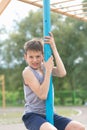 A teenager in a T-shirt climbs on a gymnastic pole Royalty Free Stock Photo