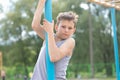 A teenager in a T-shirt climbs on a gymnastic pole Royalty Free Stock Photo