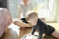 A teenager teaches his younger brother a toddler by showing a book.