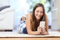 Teenager texting on the mobile phone in the living room