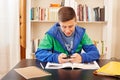 Teenager texting with smartphone while studying Royalty Free Stock Photo