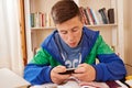 Teenager texting with smartphone while studying Royalty Free Stock Photo