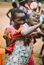TOPOSA TRIBE, SOUTH SUDAN - MARCH 12, 2020: Teenager from Toposa Tribe smiling and embracing screaming friend from behind while
