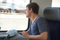 A teenager on train with his rucksack and facial mask prepared for use if needed