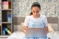 Teenager using laptop in bedroom Royalty Free Stock Photo