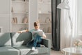 Teenager using laptop on floor near sofa in room, Boy using laptop Royalty Free Stock Photo