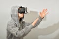 A teenager in a VR helmet is surprised by the immeasurable reality in the virtual world Royalty Free Stock Photo