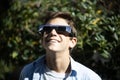 Teenager watching a total eclipse of the sun with goggles from a forest Royalty Free Stock Photo