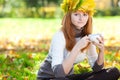 Teenager woman in a wreath of maple leaves with cu