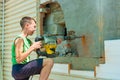 A teenager works on a construction site using an electric jackhammer, the concept of exploiting child labor Royalty Free Stock Photo