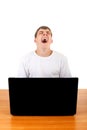 Teenager yawning behind Laptop