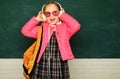 Teenager younf school girl with backpack on blackboard. Portrait of a teen female student. Funny school girl wearing Royalty Free Stock Photo