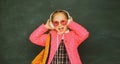 Teenager younf school girl with wearing eyeglasses backpack and headphones.