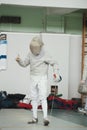 Teenager young fencer in white costume and protective mask