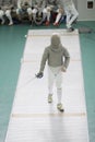 Teenager young fencer in white costume and protective mask