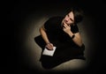 Teenager young man thinking and writing on notebook on black background