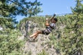 Teenager zip-lining on high ropes course, adventure, park, climbing trees in a forest Royalty Free Stock Photo