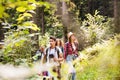 Teenagers with backpacks hiking in forest. Summer vacation. Royalty Free Stock Photo