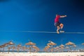 Teenagers balance slackline on summer tropical beach Royalty Free Stock Photo