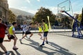 Teenagers boys play street basketball in the city. Small teams of three by three players