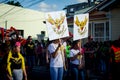 Teenagers carry emblems of small group on city street at dominican annual carnival
