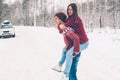 Teenagers in Christmas sweaters playing in snow in winter