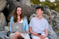 teenagers communicate in nature boy and girl with gadgets laptop phone shy look into eyes first date relationship love Royalty Free Stock Photo