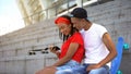 Teenagers couple smiling and scrolling social network news on smartphone device