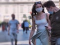 Teenagers couple walking downtown after the lockdown ends wearing protective mask