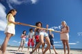 Teenagers doing limbo dance on beach