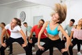 Teenagers exercising with coach in choreography class