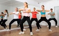 Teenagers exercising with coach in choreography class