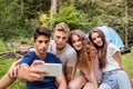Teenagers in front of tent camping in forest. Royalty Free Stock Photo