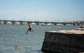 Teenagers having summer fun jumping from the rock on Matanzas River