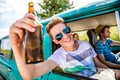 Teenagers inside an old campervan, drinking beer, roadtrip