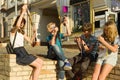 Teenagers with interest and surprise watching film photo negatives, city street background