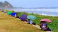 Teenagers kissing under umbrellas and looking out to sea, Sri Lanka