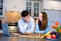 teenagers in kitchen looking after girl with loving eyes on table laptop sushi fruits flowers beautiful first date Royalty Free Stock Photo