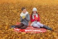 Teenagers laughing loudly talking flirt on a picnic on the plaid in the park