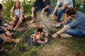 Teenagers are learning to cook sausages on fire