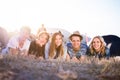 Teenagers lying on the ground in front of tents Royalty Free Stock Photo