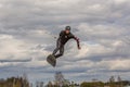 Teenagers make an extreme jump on wakeboarding and looking at the camera, around there are a lot of splashes