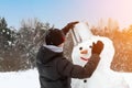 teenagers make a snowman. The concept of active winter recreation. Family holidays. Artistically colored photo