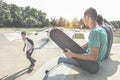 Teenagers performing with skateboard in city skate park - Young skaters doing tricks and skills outdoor - Extreme sport, youth