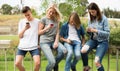 Teenagers with phones in park