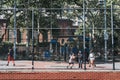 Teenagers play basketball on a public court in Brooklyn, New York, USA.