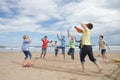 Teenagers playing baseball on beach