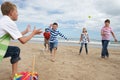 Teenagers playing baseball on beach