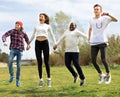 Teenagers running jumping green lawn in summer in park Royalty Free Stock Photo